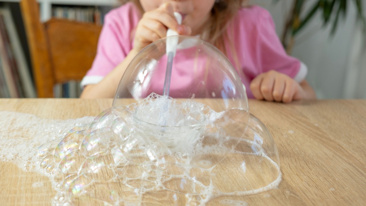 Mergaitė pučia aburbulus ant stalo